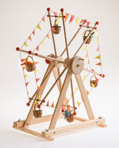 Kraul Riesenrad aus Holz mit bunten Wämpeln und Püppchen in den Körbchen, freigestellt