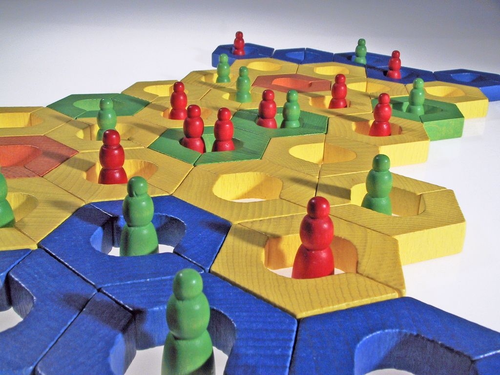 Bhavátí-Brettspiel mit bunten Holzfiguren auf Hexagonfeldern